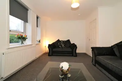 a living room with a couch and a window at Signature - Carrick View in Cumbernauld