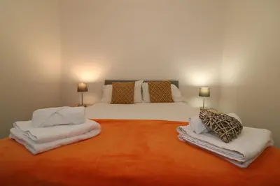 a bedroom with a large bed with towels on it at Signature - Carrick View in Cumbernauld
