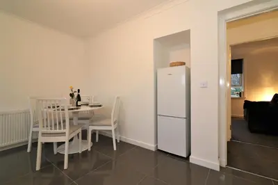a kitchen with a table and a white refrigerator at Signature - Carrick View in Cumbernauld