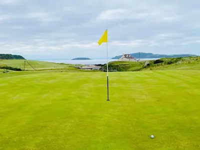 a yellow flag on a green golf course at Osborne Cottage in Southend