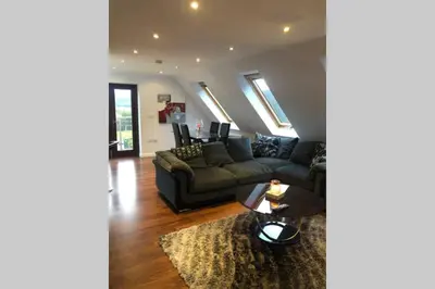a living room with a couch and a table at Struan Coach house in gated residence in Stirling