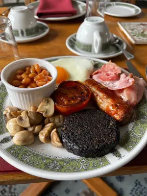 a plate of food with meat and vegetables on a table at Hawthornbank in Oban
