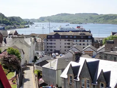 an aerial view of a city with a ship in the water at Hawthornbank in Oban