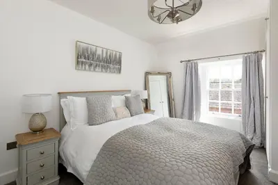 a white bedroom with a bed and a window at Stableyard Apartment: Drumlanrig Castle in Thornhill