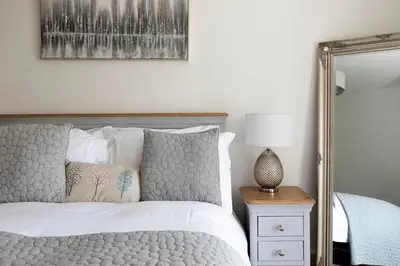 a bedroom with a bed and a mirror at Stableyard Apartment: Drumlanrig Castle in Thornhill