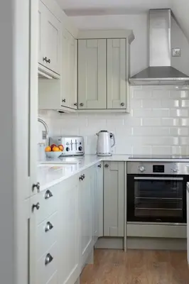 a white kitchen with white cabinets and a stove at Stableyard Apartment: Drumlanrig Castle in Thornhill
