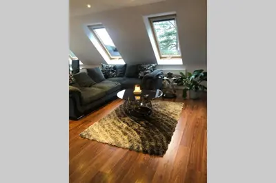 a living room with a couch and a table at Private Coach house in gated residence in Stirling