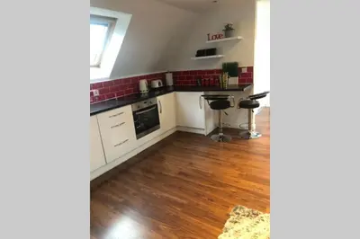 a kitchen with white cabinets and red tiles at Private Coach house in gated residence in Stirling