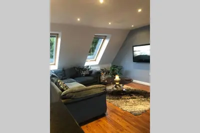 a living room with a couch and a tv at Private Coach house in gated residence in Stirling