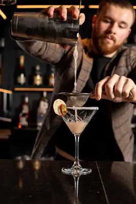 a man pours a drink into a martini glass at Moxy Edinburgh Fountainbridge in Edinburgh