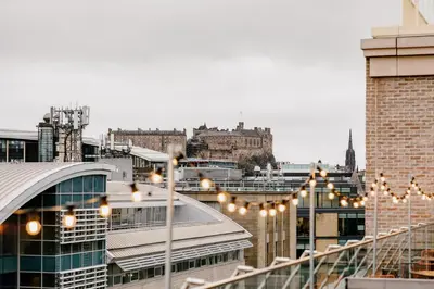 a view of a city from a rooftop with lights at Moxy Edinburgh Fountainbridge in Edinburgh
