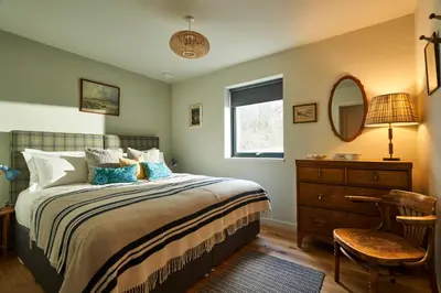 a bedroom with a bed and a dresser and a mirror at An Airigh in Cairndow