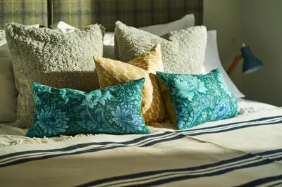 a bed with a bunch of pillows on it at An Airigh in Cairndow