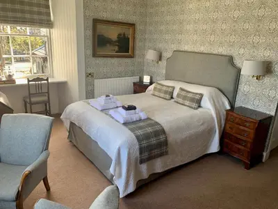 a bedroom with a bed with two towels on it at The Manor House in Oban
