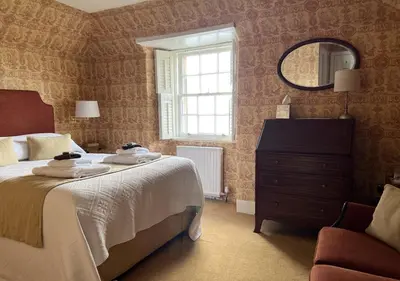 a bedroom with a bed and a mirror and a dresser at The Manor House in Oban