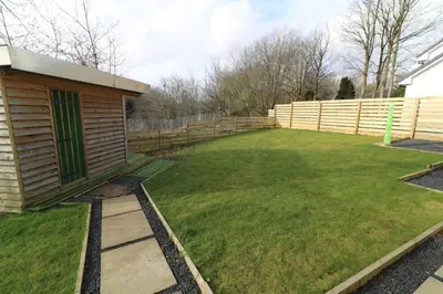 a garden with a wooden fence and a yard at Signature - Railway Cottage in Maryhill