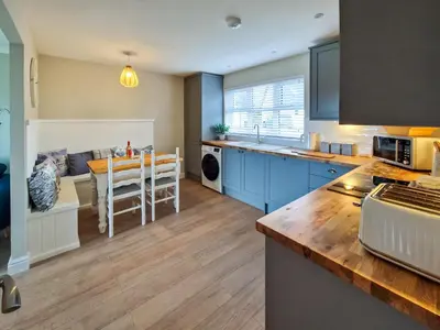 a kitchen with blue cabinets and a table in it at Ar Deireadh in Tayvallich