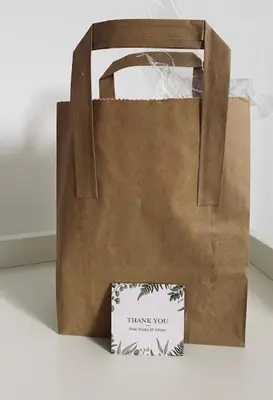 a paper bag with a thank you sign next to a chair at Glenfinnan - Two Bedroom Apartment in Fife