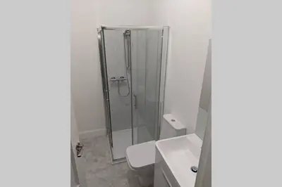a bathroom with a shower and a toilet and a sink at Glenfinnan - Two Bedroom Apartment in Fife