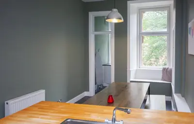 a kitchen with a wooden table and a window at Modern, Light-filled and Sleek West End Apartment in Glasgow