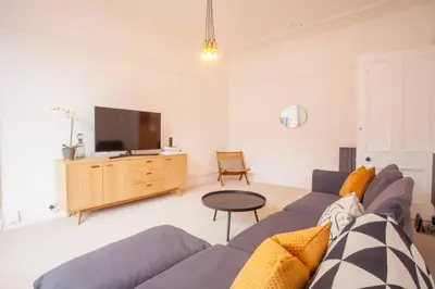 a living room with a blue couch and a tv at Stunning 2 bed property in heart of West End in Glasgow