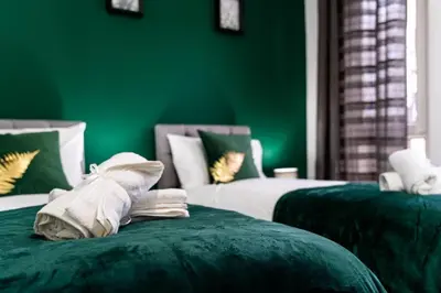 a green room with two beds with green walls at Cheerful 2 Bedroom Homely Apartment, Sleeps 4 Guest Comfy, 1x Double Bed, 2x Single Beds, Free Parking, Free WiFi, Suitable For Business, Leisure Guest, Contractors, QE Hospital, Glasgow, Near Airport & City Centre, Perfect For Common Wealth Games 2026 in Glasgow