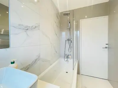 a white bathroom with a shower and a toilet at Cardonald Central in Glasgow