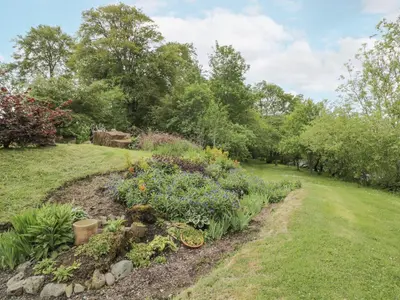 a garden with a bike in the grass at Torview House in Peebles