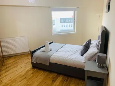 a bedroom with a bed and a window at Modern 2 Bed Apartment, Close to Gla Airport & M8 in Paisley