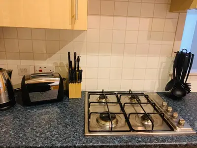 a stove top oven sitting on a kitchen counter at Modern 2 Bed Apartment, Close to Gla Airport & M8 in Paisley