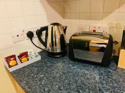 a toaster sitting on top of a counter next to a toaster at Modern 2 Bed Apartment, Close to Gla Airport & M8 in Paisley