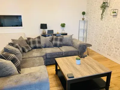 a living room with a couch and a table at Modern 2 Bed Apartment, Close to Gla Airport & M8 in Paisley