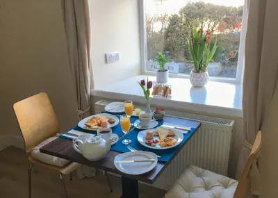 a table with plates of food on it with a window at An Cuan Bed & Breakfast in Bowmore