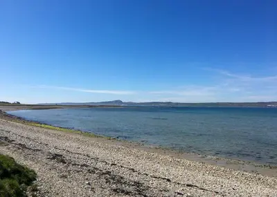 a rocky beach with the ocean in the background at An Cuan Bed & Breakfast in Bowmore