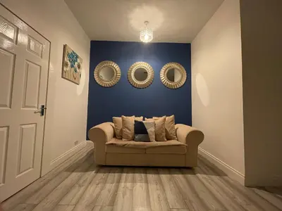 a living room with a couch and two mirrors at HLA Holytown in Mossend