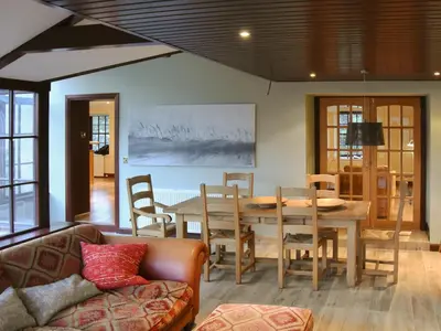 a living room with a table and chairs and a couch at Stronafian House in Feorlean