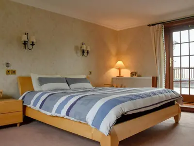 a bedroom with a large bed and a window at Stronafian House in Feorlean