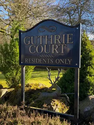 a sign for a guthrie court with a tree behind it at Gleneagles Luxury Apartments in Auchterarder