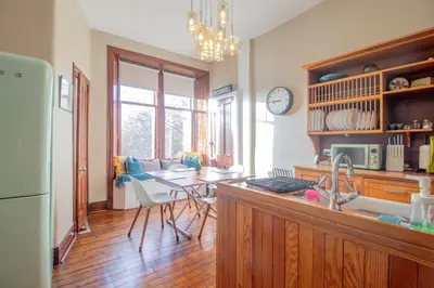 a kitchen with a counter and a table with a dining room at Beautiful, traditional 2 bed flat w free parking - Pass the Keys in Glasgow
