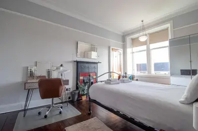 a bedroom with a bed and a desk and a chair at Beautiful, traditional 2 bed flat w free parking - Pass the Keys in Glasgow