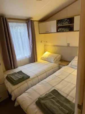 two beds in a room with a window at Deer lodge in Auchterarder