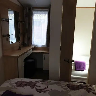 a bedroom with a bed and a desk and a window at Deer lodge in Auchterarder