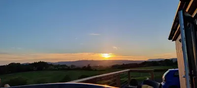 a view of the sunset from the balcony of a house at Cleeves Cabins Ailsa Luxury Lodge with hot tub in Dalry
