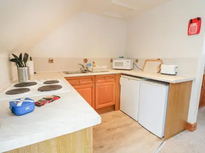 a kitchen with a stove and a white refrigerator at MacKintosh in Pitlochry