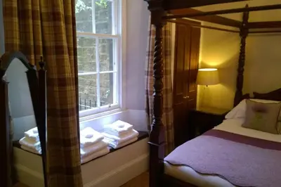 a bedroom with a canopy bed and a window at Old Town 163 in Edinburgh