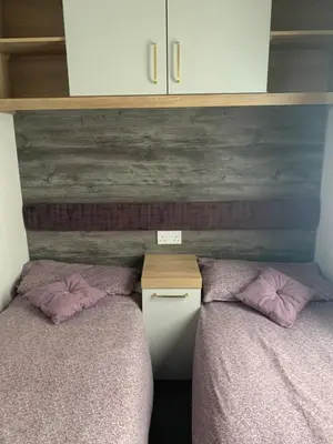 two beds with pink pillows in a bedroom at Swift Bordeaux Sea View No 3 in Dunoon