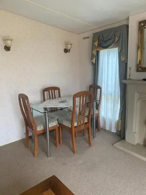a dining room with a table and chairs and a fireplace at The Monaco 32 in Dunoon