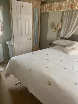 a bedroom with a large bed with a white comforter at The Monaco 32 in Dunoon