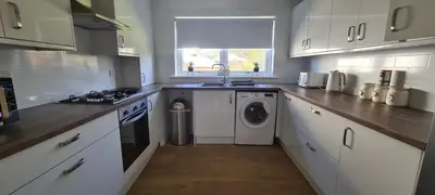 a kitchen with a washing machine and a washer and dryer at Craiglynn Holiday Apartment Loch Lomond in Balloch