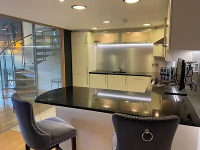 a kitchen with a counter top and two chairs at Perfect In The Park in Glasgow